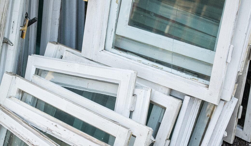 mehrere kaputte Holzfenster liegen auf einem Stapel