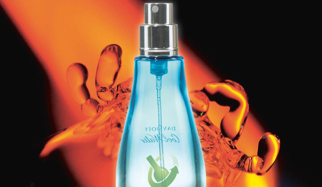 Man sieht eine Parfumflasche vor einem orangen Hintergrund